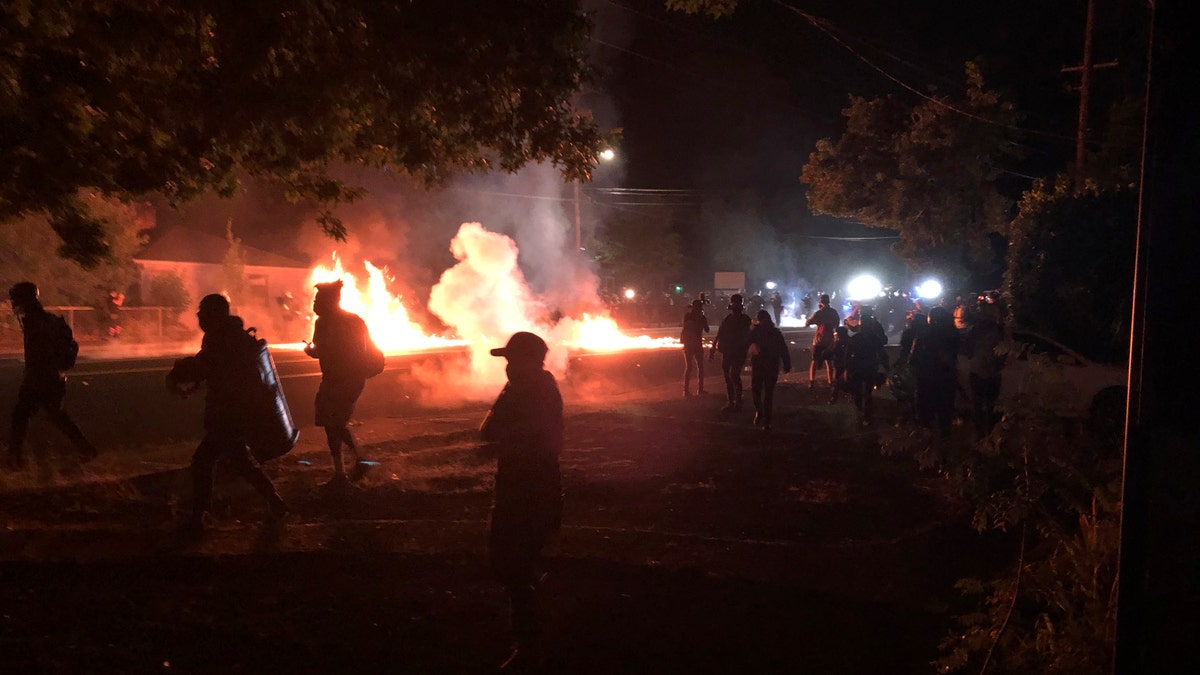 Flames rise from a street after a liquid had been spread and lit, Saturday, Sept. 5, 2020, during protests in Portland, Ore. (AP Photo/Andrew Selsky)