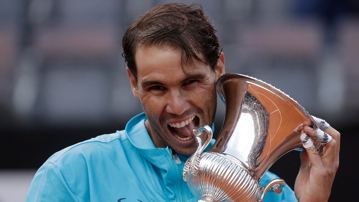 In this May 19, 2019 file photo, Rafael Nadal of Spain holds his trophy after winning against Novak Djokovic of Serbia at the end of their final match at the Italian Open tennis tournament, in Rome. (AP Photo/Gregorio Borgia)