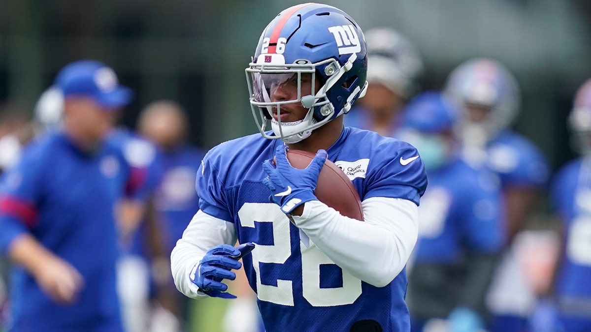 New York Giants' Saquon Barkley runs the ball during practice at the NFL football team's training camp in East Rutherford, N.J., Wednesday, Aug. 19, 2020. (AP Photo/Seth Wenig)