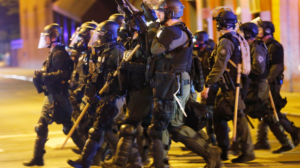 FILE - In this Sunday, May 31, 2020, file photo, police in riot gear advance on protesters as they attempt to clear the streets in Richmond, Va. Virginia lawmakers are pushing for changes to make it easier to decertify problem police officers and more difficult for them to hop from department to department. (AP Photo/Steve Helber, File)