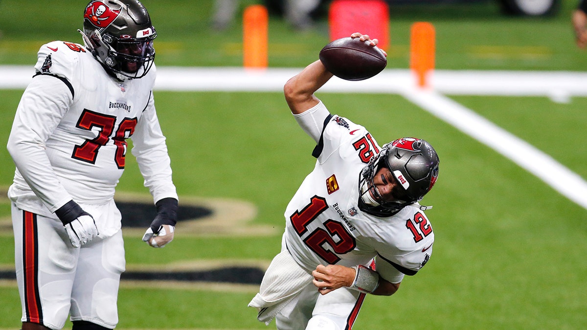 Tampa Bay Buccaneers quarterback Tom Brady (12) celebrates his touchdown with offensive tackle Donovan Smith (76) in the first half of an NFL football game against the New Orleans Saints in New Orleans, Sunday, Sept. 13, 2020. (AP Photo/Brett Duke)
