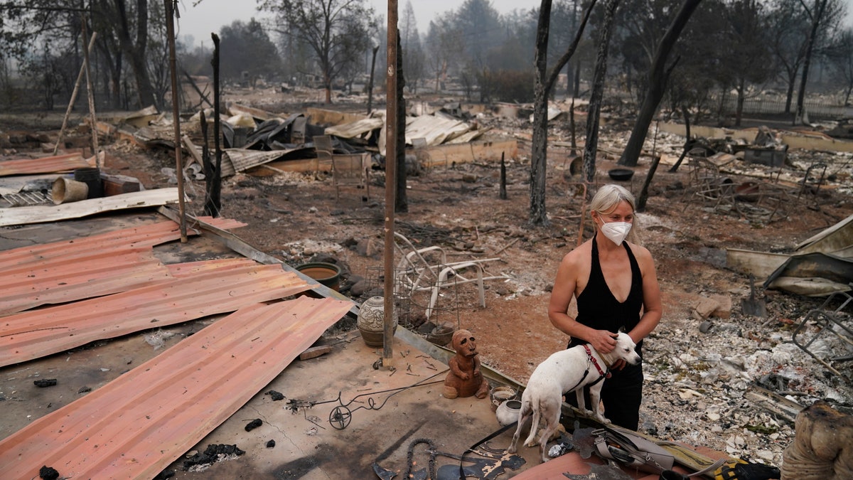 Eden McCarthy pets her dog Hina in the rubble of her home destroyed by the Almeda Fire on Thursday in Talent, Ore. (AP)