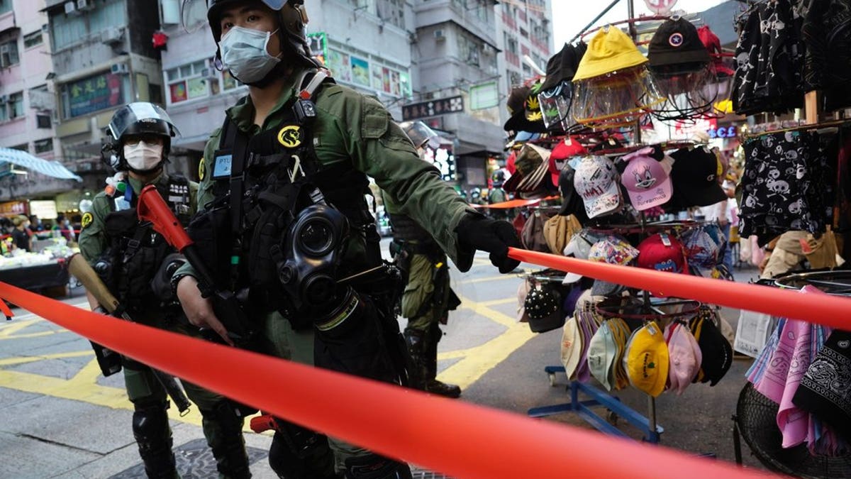Police officers stand guard at a downtown street in Hong Kong Sunday, Sept. 6, 2020. About 30 people were arrested Sunday at protests against the government's decision to postpone elections for Hong Kong's legislature, police and a news report said. (AP Photo/Vincent Yu)