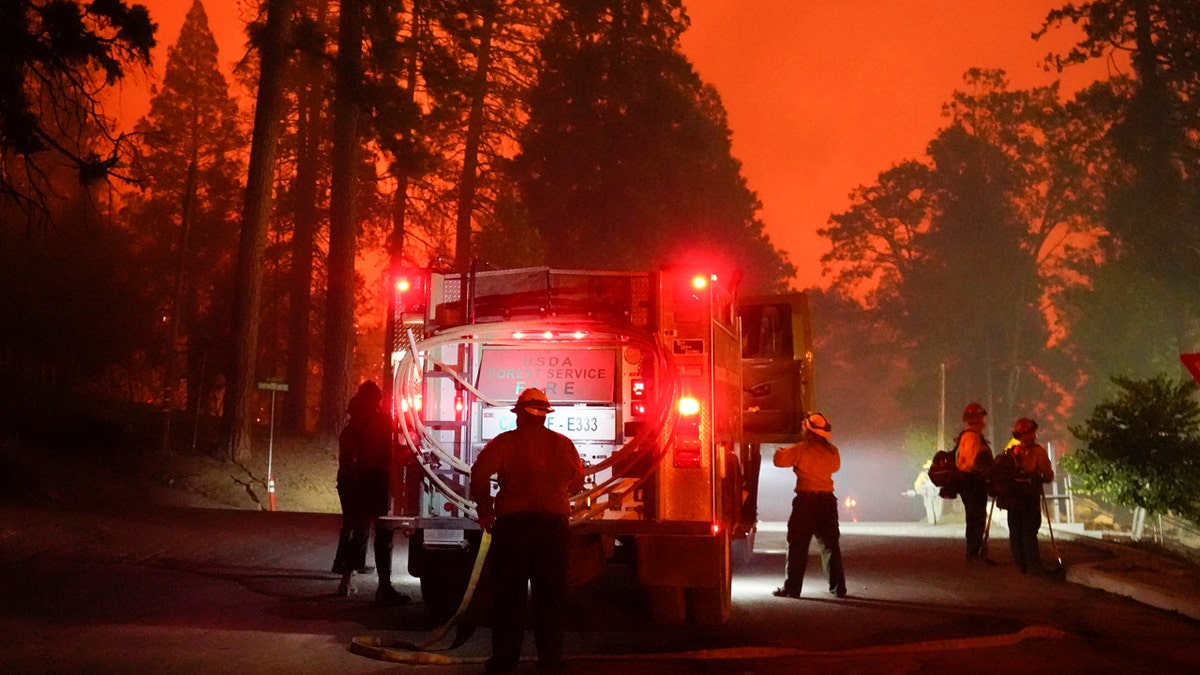 Firefighters stage near a Southern California Edison power station to protect it from the advancing Creek Fire, Sunday, Sept. 6, 2020, in Big Creek, Calif.