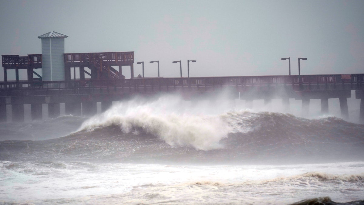 Waves crash near a pier, at Gulf State Park, Tuesday, Sept. 15, 2020, in Gulf Shores, Ala. Hurricane Sally is crawling toward the northern Gulf Coast at just 2 mph, a pace that's enabling the storm to gather huge amounts of water to eventually dump on land. (AP Photo/Gerald Herbrt)
