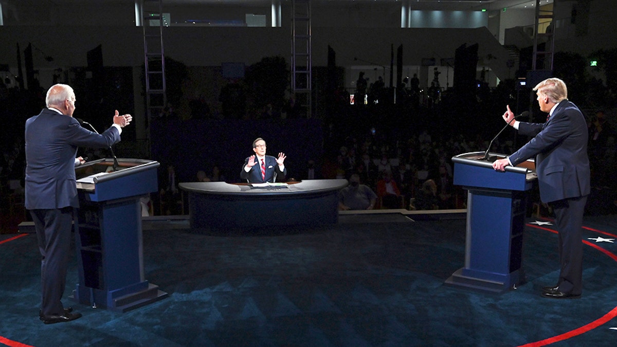 Donald Trump (l) and Joe Biden talk in the presidential debate Tuesday, Sept. 29, 2020, at Case Western University and Cleveland Clinic, in Cleveland, as moderator Chris Wallace speaks. (Olivier Douliery/Pool vi AP)