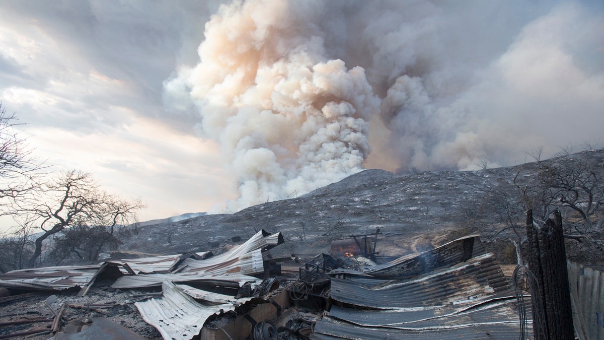 In this Saturday, Sept. 5, 2020, file photo, a burned structure is seen from a wildfire in Yucaipa, Calif. that was caused by a gender-reveal party.
