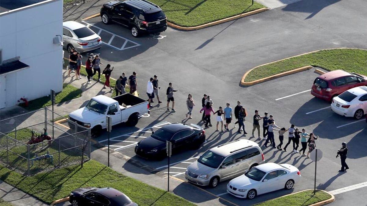 Students shown evacuating Marjory Stoneman Douglas High School after Nikolas Cruz opened fire