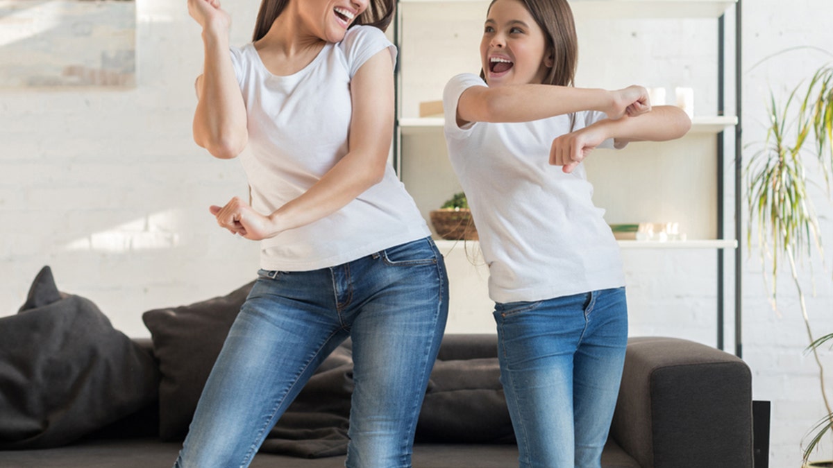 mulher e menina dançando juntas