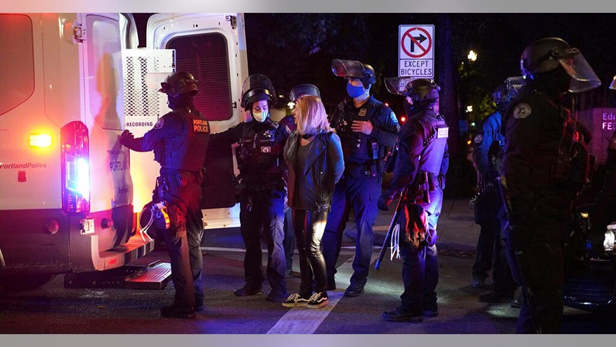A female protester is loaded into a van after being arrested while rallying at the Mark O. Hatfield United States Courthouse on Saturday, Sept. 26, 2020, in Portland, Ore. (Associated Press)