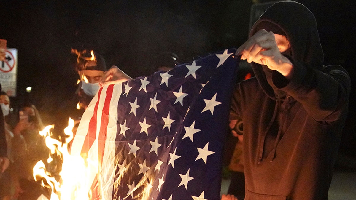 A protester burns an American flag while rallying at the Mark O. Hatfield United States Courthouse on Saturday, Sept. 26, 2020, in Portland, Ore. (Associated Press)