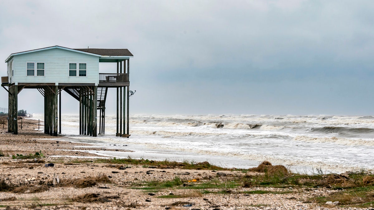 A house sits on the beach on Bolivar Peninsula, Texas, buffeted by the winds and rough surf, Sunday, Sept. 20, 2020.