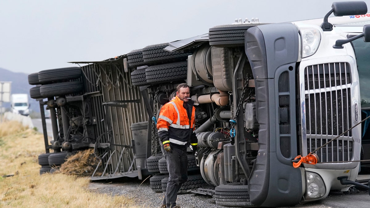 A semi rests on its side after after high winds toppled it on Interstate 15 Tuesday, Sept. 8, 2020, near Bountiful, Utah.