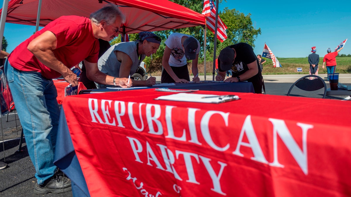 People register to vote during a GOP event in Brownsville, Pa., on Sept. 5, 2020. Less than two months before the Nov. 3 presidential election, the contrast between Republicans and Democrats is striking in Washington County, in the suburbs of Pittsburgh. (Photo by ANDREW CABALLERO-REYNOLDS/AFP via Getty Images)