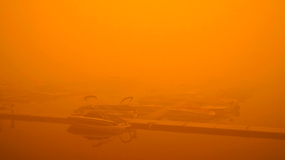 Boats are partially obscured by smoke from a wildfire at a marina on Detroit Lake burned by the Beachie Creek Fire, Saturday, Sept. 12, 2020, in Detroit, Ore.