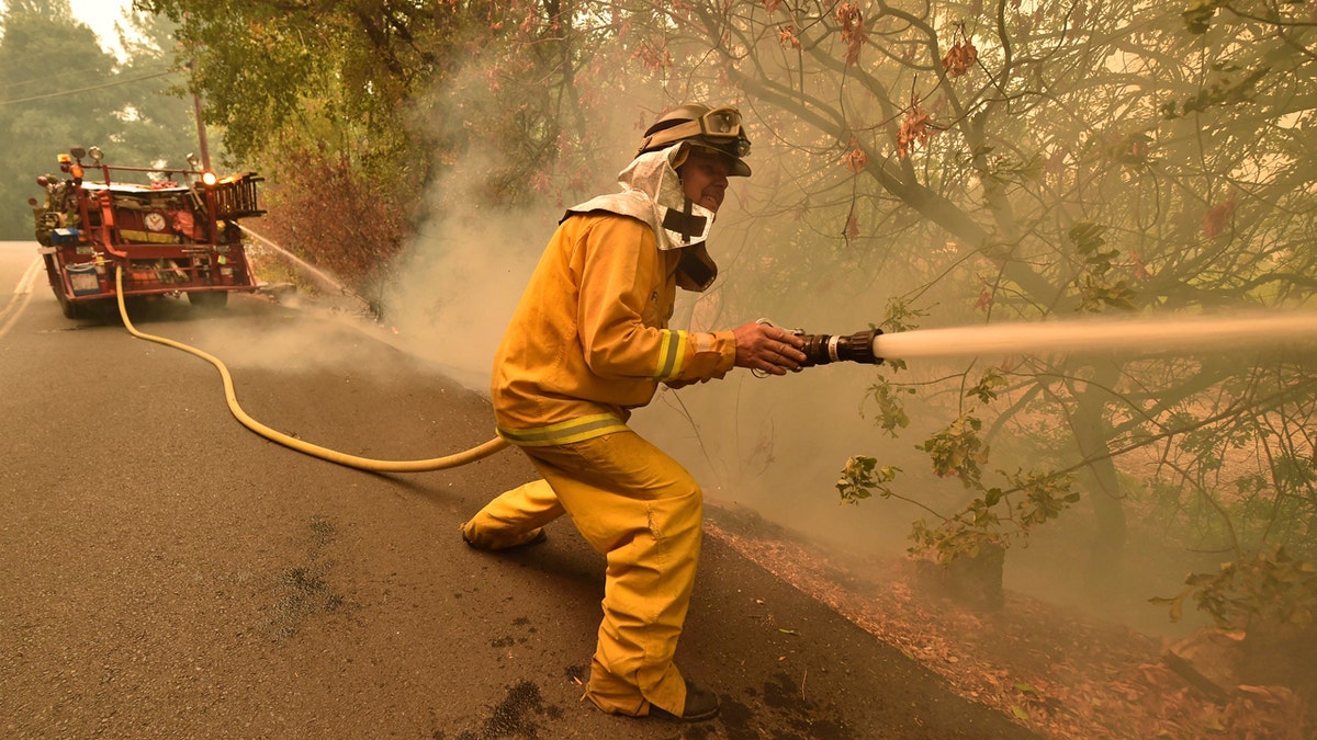 Eagle Field Fire Department firefighter Mark Jones extinguishes hot spots during the Glass Fire in St. Helena, Calif., on Monday, Sept. 28, 2020.