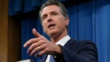 Gov. Gavin Newsom talks to reporters at his Capitol office in Sacramento, Calif. Newsom signed into law Wednesday a bill that would establish a nine-member task force to study and develop reparations proposals for the descendants of Black slaves. (AP Photo/Rich Pedroncelli, File)