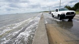 Waters from the Guld of Mexico poor onto a local road, Monday, Sept. 14, 2020, in Waveland, Miss.