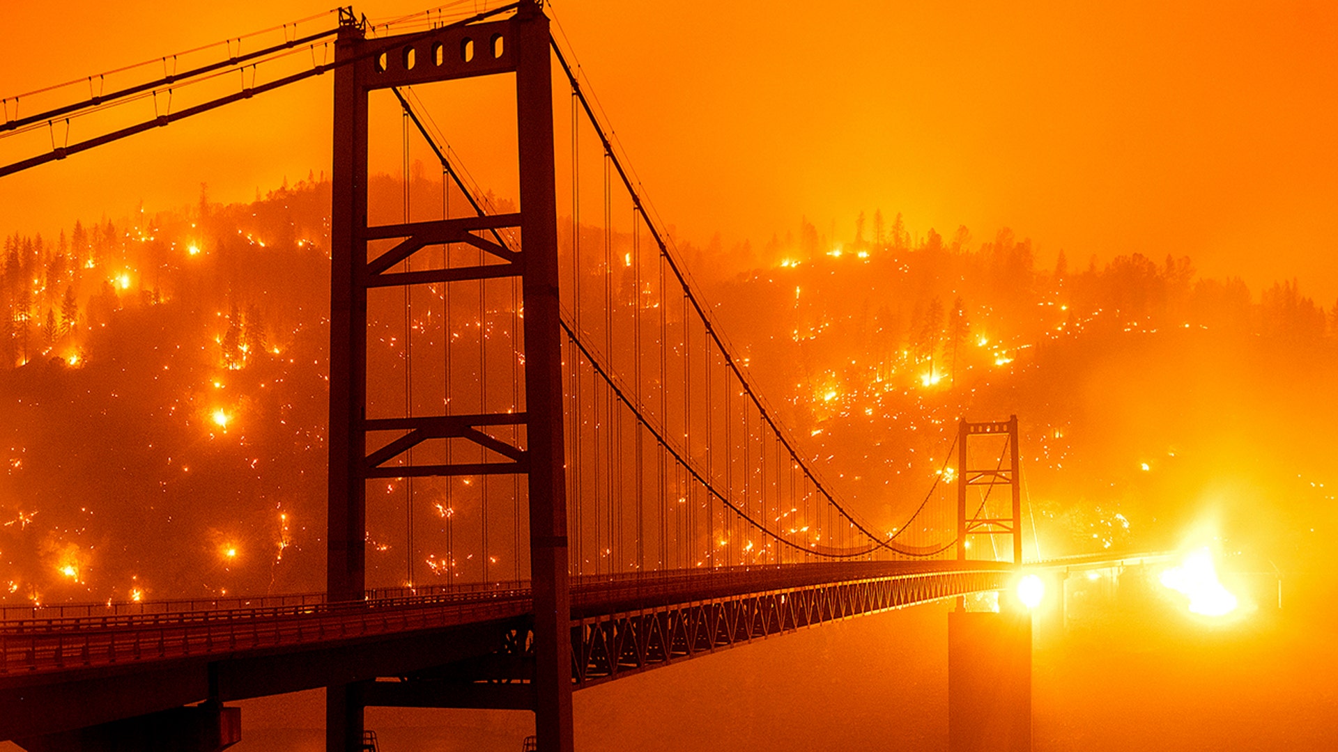 Embers light up a hillside behind the Bidwell Bar Bridge as the Bear Fire burns in Oroville, California, Sept. 9, 2020. 
