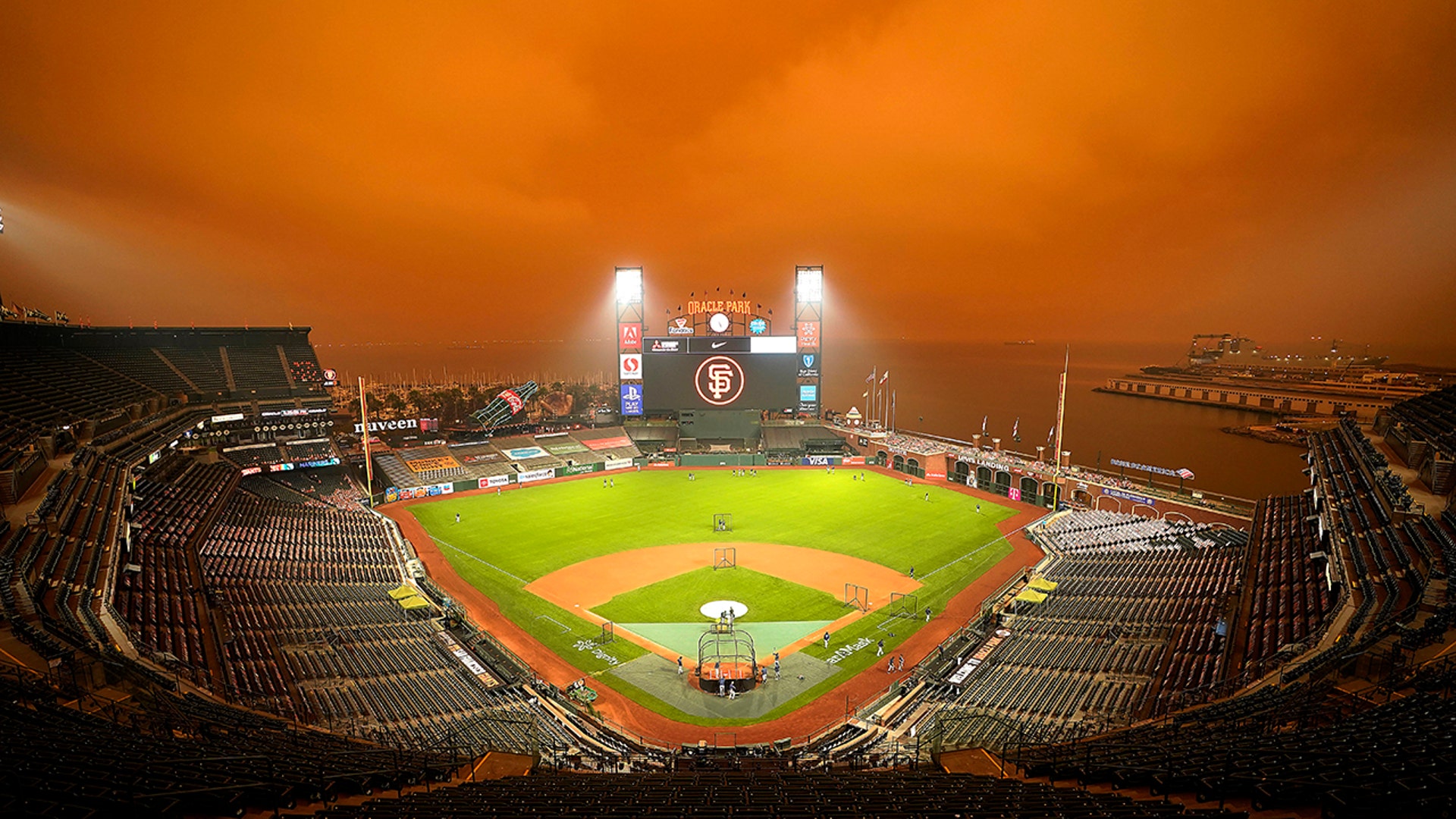 Smoke from California wildfires obscures the sky over Oracle Park as the Seattle Mariners take batting practice before their baseball game against the San Francisco Giants in San Francisco, Sept. 9, 2020.