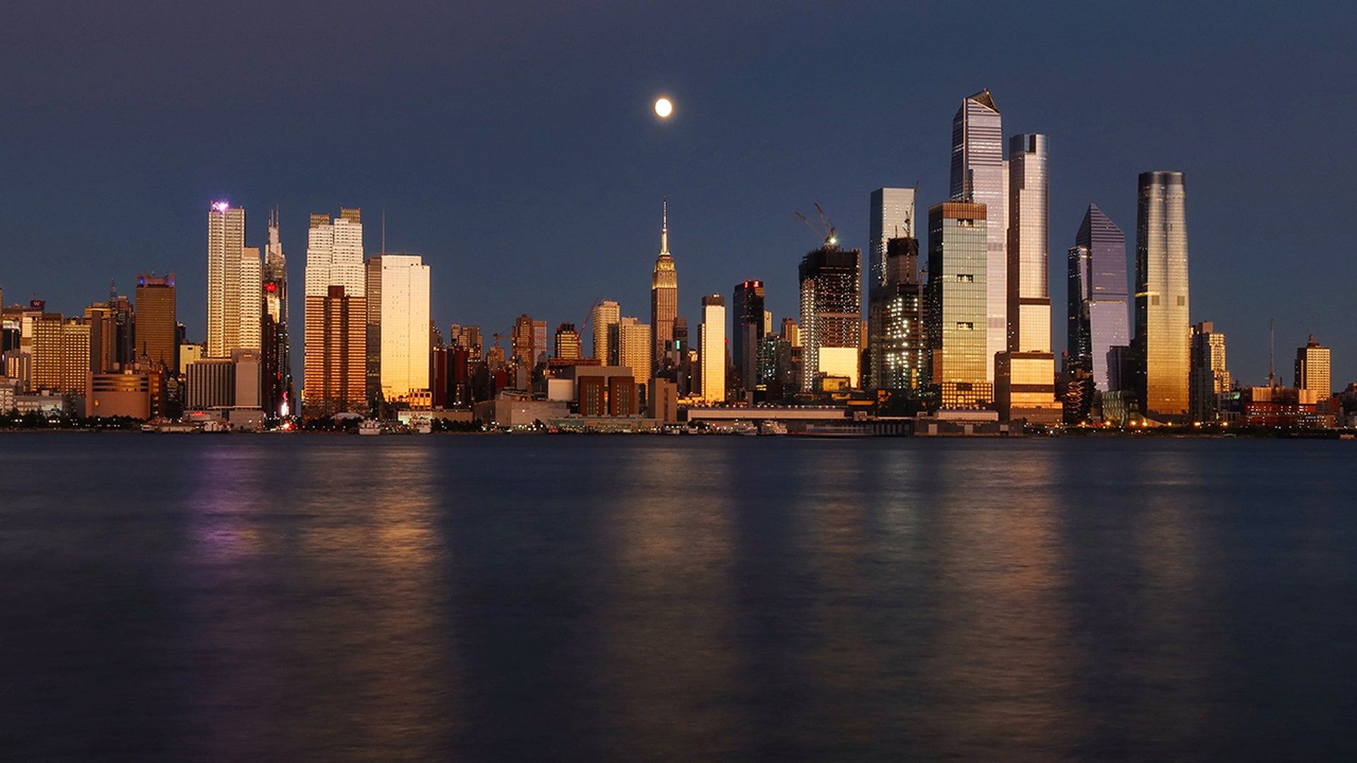 The moon rises over the Empire State Building in New York City, Aug. 30, 2020.