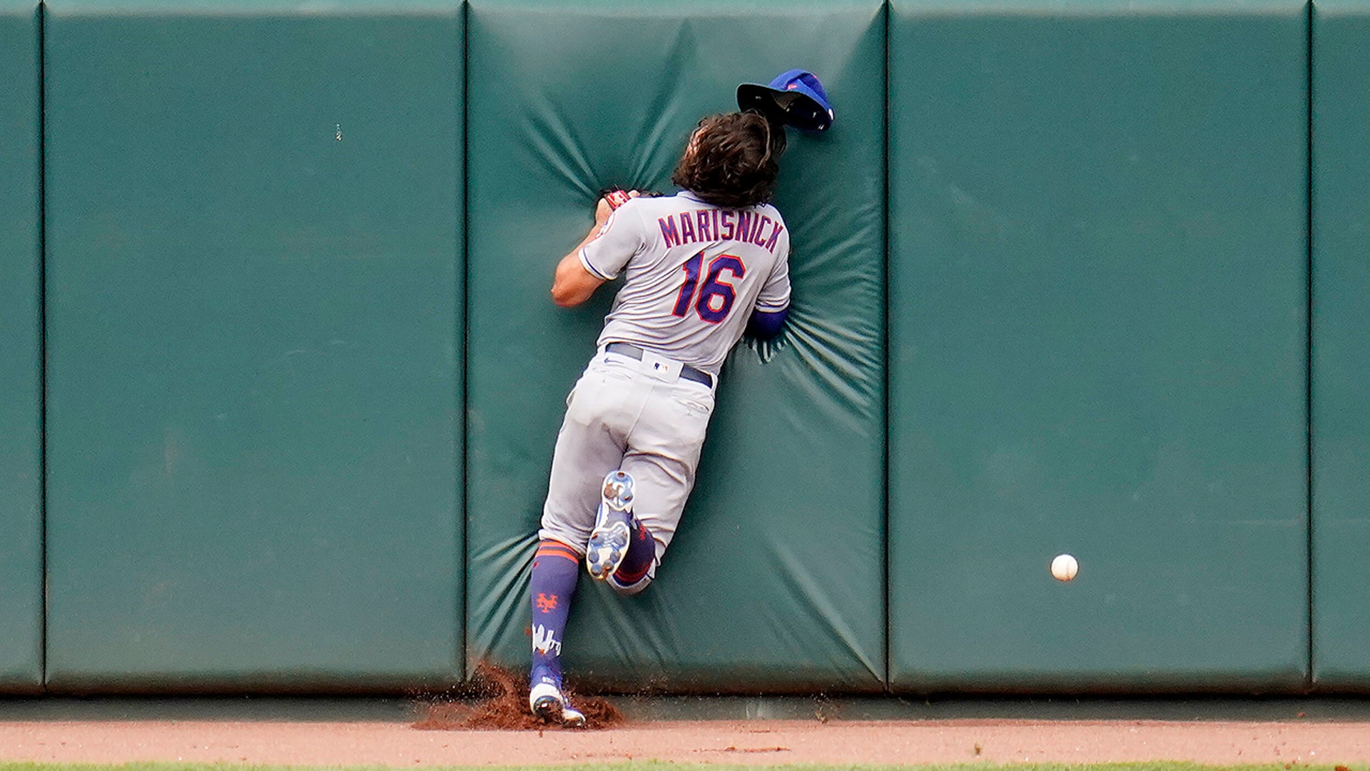 New York Mets center fielder Jake Marisnick hits the center-field wall while chasing a triple by Baltimore Orioles' Pedro Severino during their baseball game, in Baltimore, Sept. 2, 2020. 