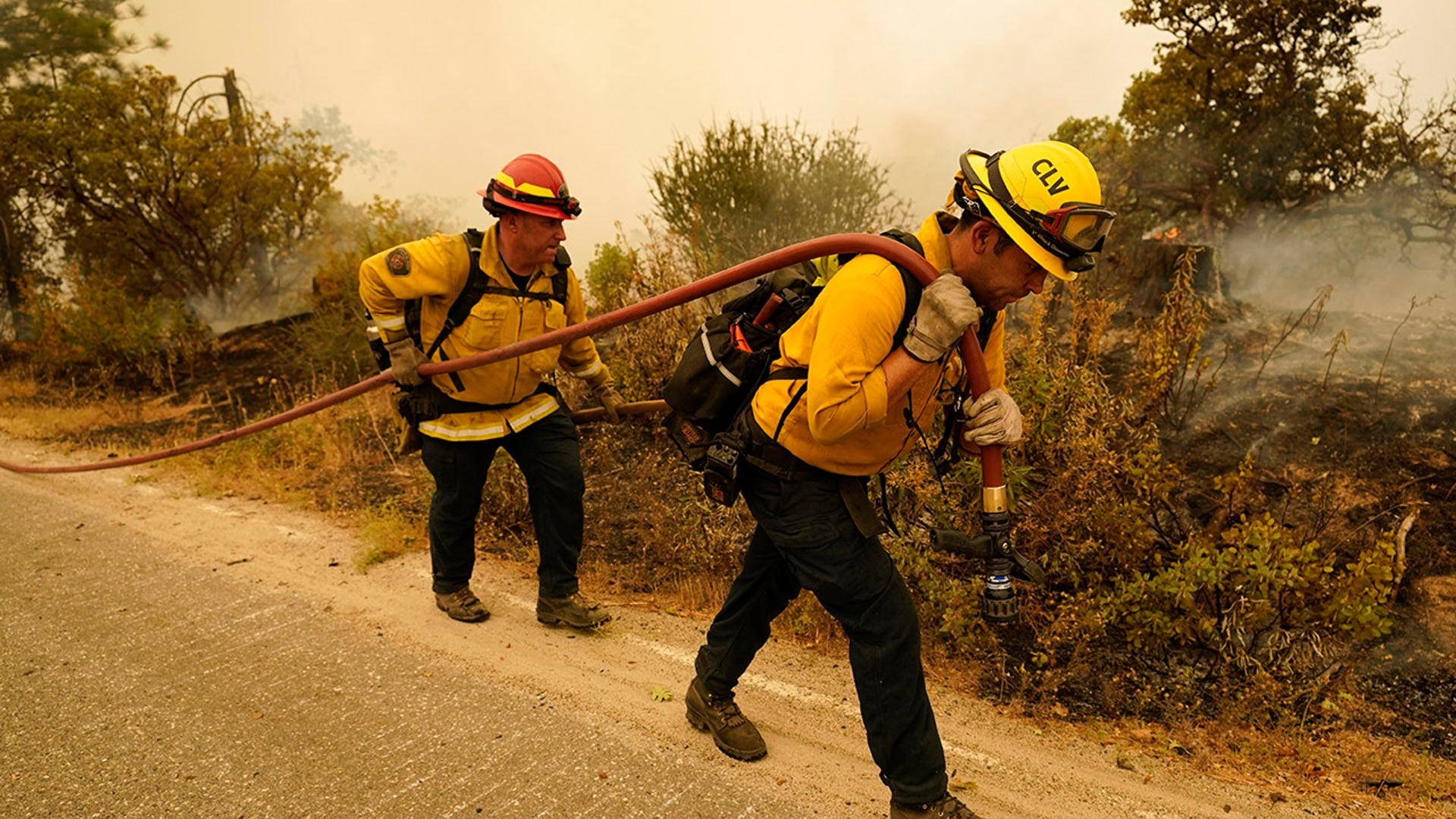 Tim Lesmeister, left, and Rick Archuleta, of the Clovis Fire Department, walk along a road monitoring hotspots left behind by the Creek Fire Tuesday, Sept. 8, 2020, in Tollhouse, Calif.