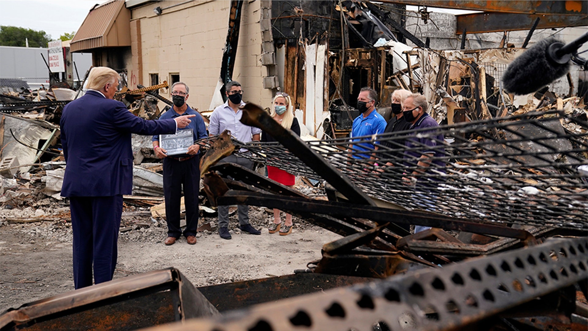 President Trump talks to business owners Tuesday, as he tours an area damaged during demonstrations after a police officer shot Jacob Blake in Kenosha, Wis. 