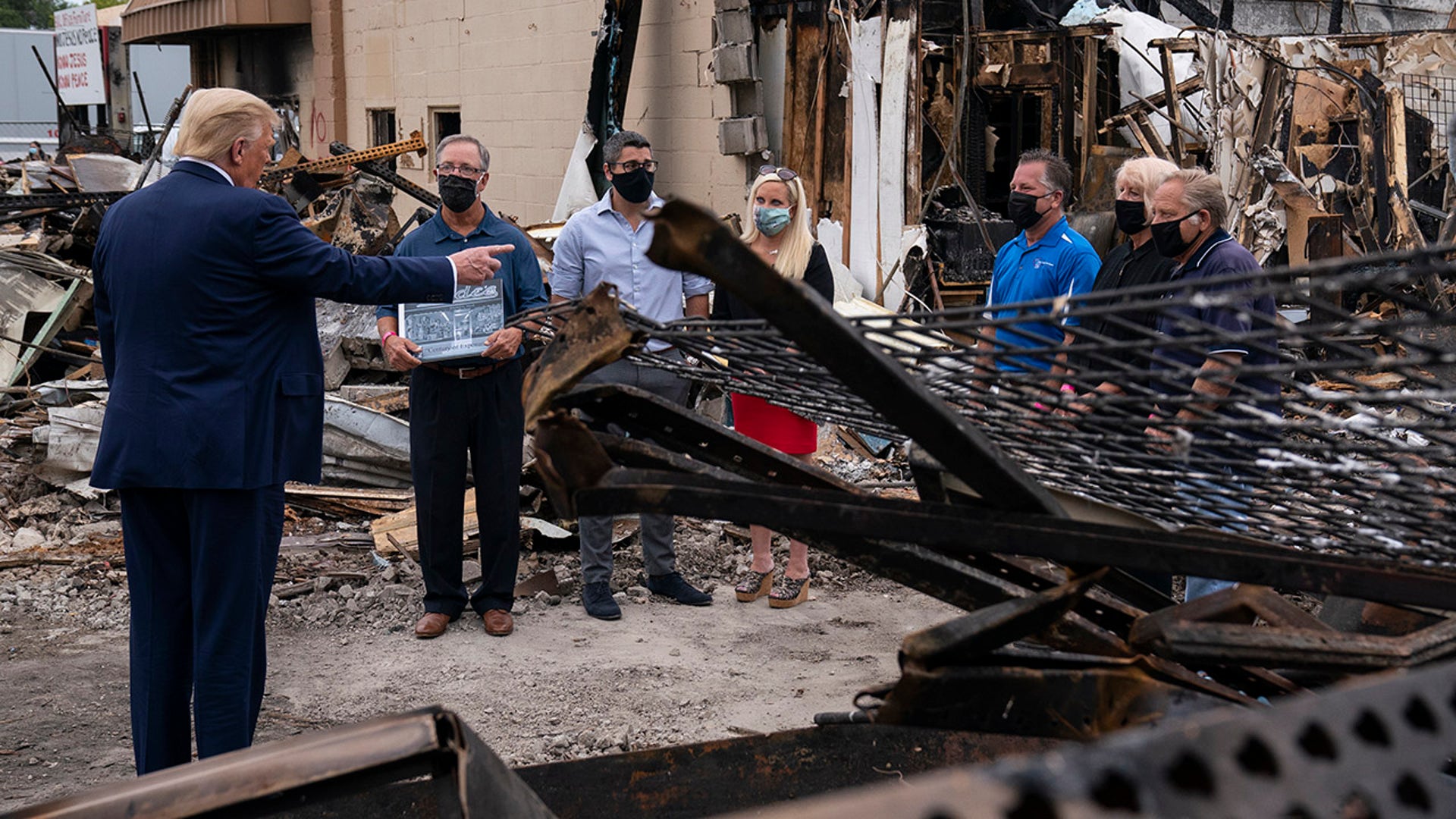 President Donald Trump speaks with business owners Tuesday, Sept. 1, 2020, as he tours an area damaged during demonstrations after a police officer shot Jacob Blake in Kenosha, Wis. (AP Photo/Evan Vucci)