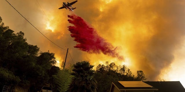 FILE - In this Aug. 18, 2020, file photo, an air tanker drops retardant as the LNU Lightning Complex fires tear through the Spanish Flat community in unincorporated Napa County, Calif. Two unusual weather phenomena combined to create some of the most destructive wildfires the West Coast states have seen in modern times. (AP Photo/Noah Berger, File)