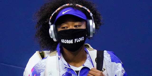 Naomi Osaka of Japan wears a protective mask due to the COVID-19 virus outbreak, featuring the name "George Floyd," while arriving on court to face Shelby Rogers of the United States during the quarterfinal round of the US Open tennis championships, Tuesday, Sept. 8, 2020, in New York. (AP Photo/Frank Franklin II)