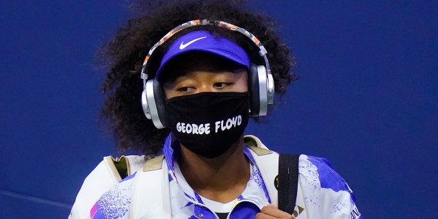 Naomi Osaka of Japan wears a protective mask due to the COVID-19 virus outbreak, featuring the name "George Floyd," while arriving on court to face Shelby Rogers of the United States during the quarterfinal round of the US Open tennis championships, Tuesday, Sept. 8, 2020, in New York. (AP Photo/Frank Franklin II)