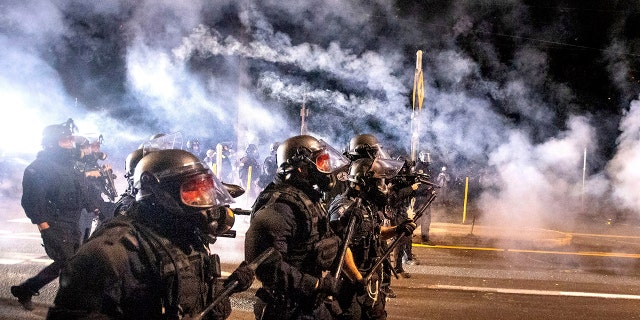 Police use chemical irritants and crowd control munitions to disperse protesters during the 100th consecutive day of demonstrations in Portland, Ore., on Saturday, Sept. 5, 2020. AP Photo/Noah Berger)