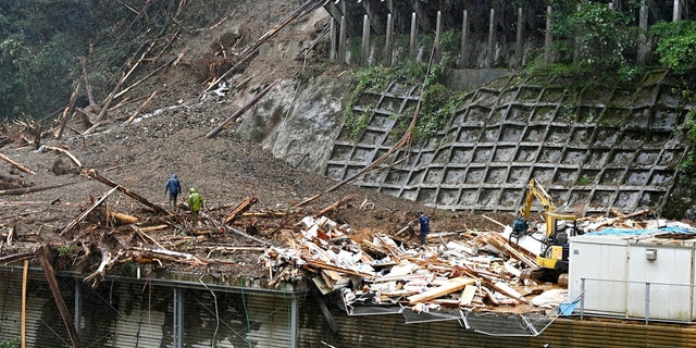 Rescuers work at a landslide site as a typhoon hit Shiiba village, Miyazaki prefecture, southwestern Japan Monday, Sept. 7, 2020.