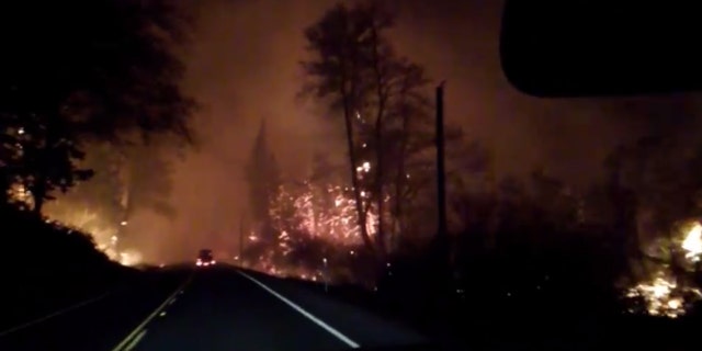 Flames can be seen Oregon Highway 18 in Lincoln County on Sept. 9, 2020 are residents evacuate from wildfires in the area.