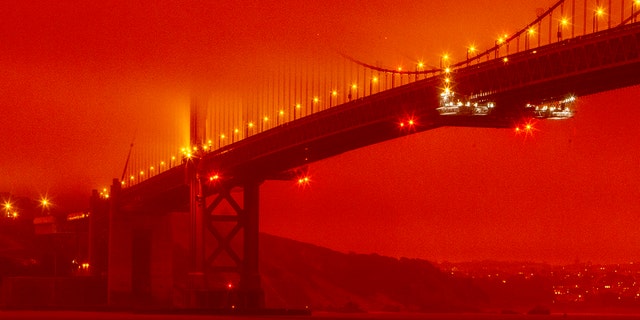 In this photo provided by Frederic Larson, the Golden Gate Bridge is seen at 11 a.m. PT, Sept. 9, in San Francisco, amid a smoky, orange hue caused by the ongoing wildfires. (Frederic Larson via AP)