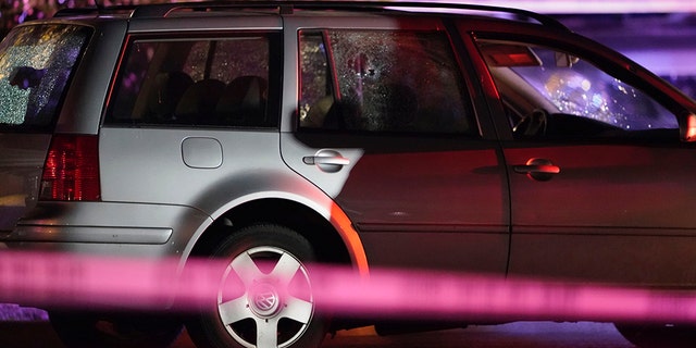 A car with shattered windows and likely bullet holes stands in the area where a man suspected of fatally shooting a supporter of a right-wing group in Portland, Ore., last week was killed as investigators moved in to arrest him in Lacey, Wash., Thursday, Sept. 3, 2020. (Associated Press)