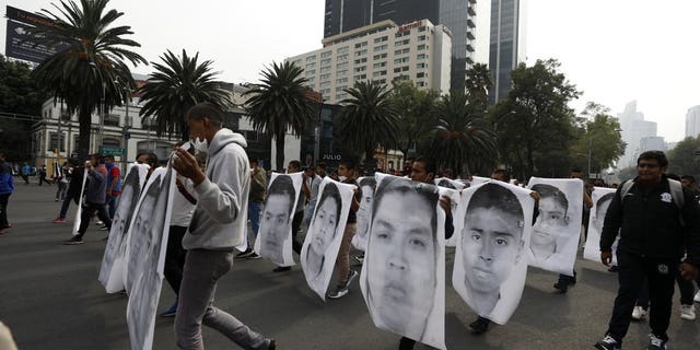 College students join family members of 43 missing students from the Rural Normal School of Ayotzinapa in a march marking the sixth anniversary of the 43 students' enforced disappearance, in Mexico City, Saterdag, Sept.. 26, 2020. (AP Photo/Rebecca Blackwell)