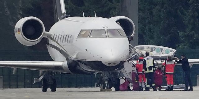 FILE-In this Aug. 22, 2020 file photo a stretcher is taken from special aircraft with the Kremlin critic Alexei Navalny on board at Tegel Airport in Berlin. Germany is increasing pressure on Russia over the poisoning of Russian opposition politician Alexei Navalny, warning that a lack of support by Moscow in the investigation could “force” Germany to rethink the fate of a German-Russian pipeline project. ( Michael Kappeler/dpa via AP)