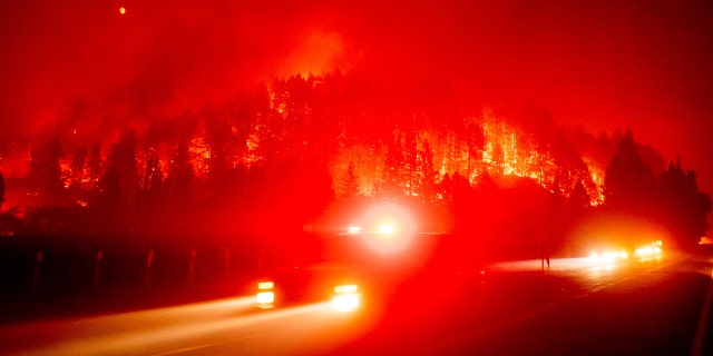 An emergency vehicle drives along Silverado Trail as the Glass Fire burns in St. Helena, Calif., Sunday, Sept. 27, 2020.
