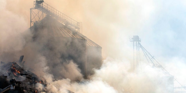 Grain from a collapsed grain elevator burns on Tuesday, Aug. 8, 2020, in Pine City, Wash. The grain elevator collapsed when a wildfire swept through town on Monday.