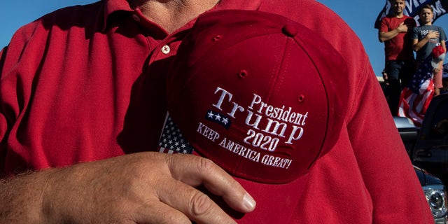 A man takes off his hat in prayer during a rally in support of President Donald Trump on Aug. 29, in Clackamas, Ore. (AP Photo/Paula Bronstein)