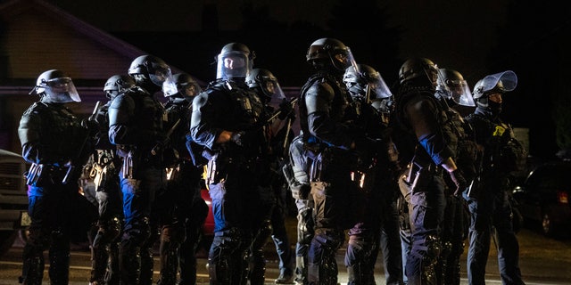 Portland police take control of the streets after making arrests on the scene of the nightly protests at a Portland police precinct on Sunday, Aug. 30, 2020, in Portland, Ore. (AP Photo/Paula Bronstein)