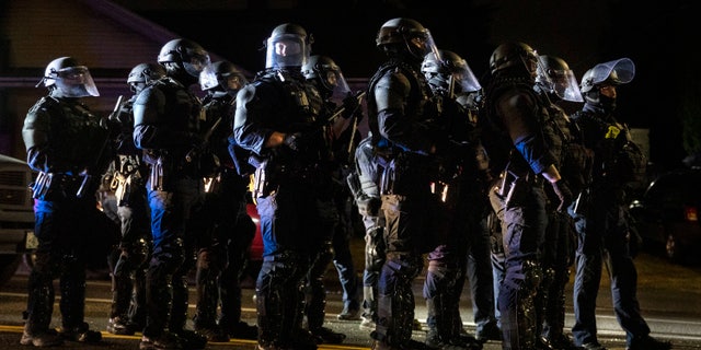 Portland police take control of the streets after making arrests on the scene of the nightly protests at a Portland police precinct on Sunday, Aug. 30, 2020, in Portland, Ore. (AP Photo/Paula Bronstein)