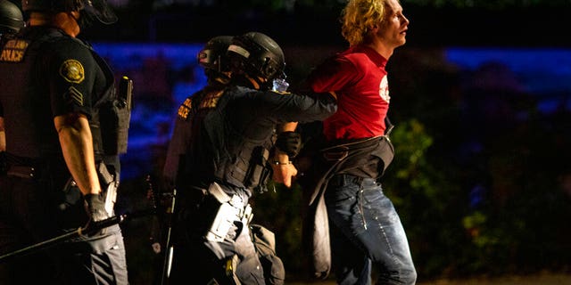 Portland police make arrests on the scene of the nightly protests at a Portland police precinct on Sunday, Aug. 30, 2020 in Portland, Ore.