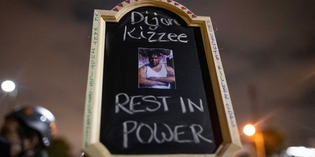 A protester holds a sign with a picture of Dijon Kizzee, who died after being shot by deputies of the Los Angeles Sheriff's Department on Aug. 31, in Los Angeles. (AP Photo/Christian Monterrosa)