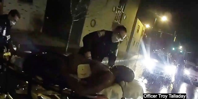 Rochester police officers prepare to load Daniel Prude into an ambulance. (Rochester Police via Roth and Roth LLP via AP)