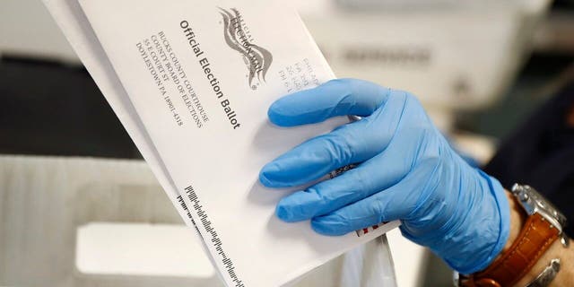 A worker processes mail-in ballots at the Bucks County Board of Elections office prior to the primary election in Doylestown, Pennsylvania, on May 27, 2020.