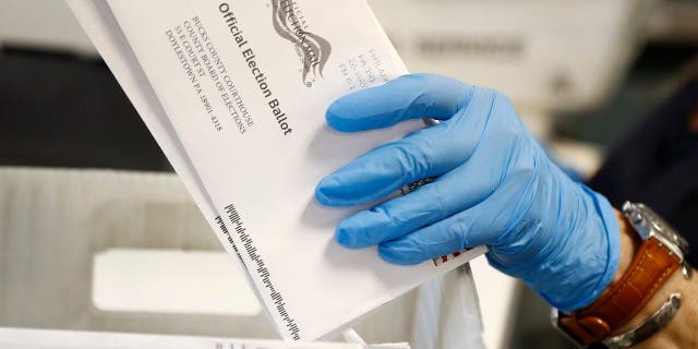 A worker processes mail-in ballots at the Bucks County Board of Elections office prior to the primary election in Doylestown, Pennsylvania, May 27, 2020.