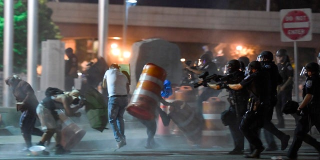 Police officers force a line of demonstrators away from the front of the Public Safety Building in Rochester, N.Y., last week. (AP Photo/Adrian Kraus)